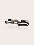 Three hair claw clips in black, clear, and tortoiseshell patterns, arranged horizontally on a light beige background.
